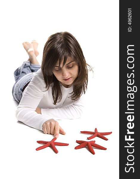 Young beautiful woman playing with red starfish isolated on white background
