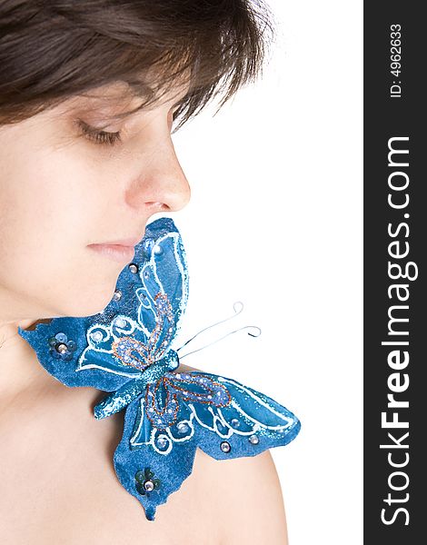 Beautiful young woman with blue butterfly in her naked shoulder - focus on the eye