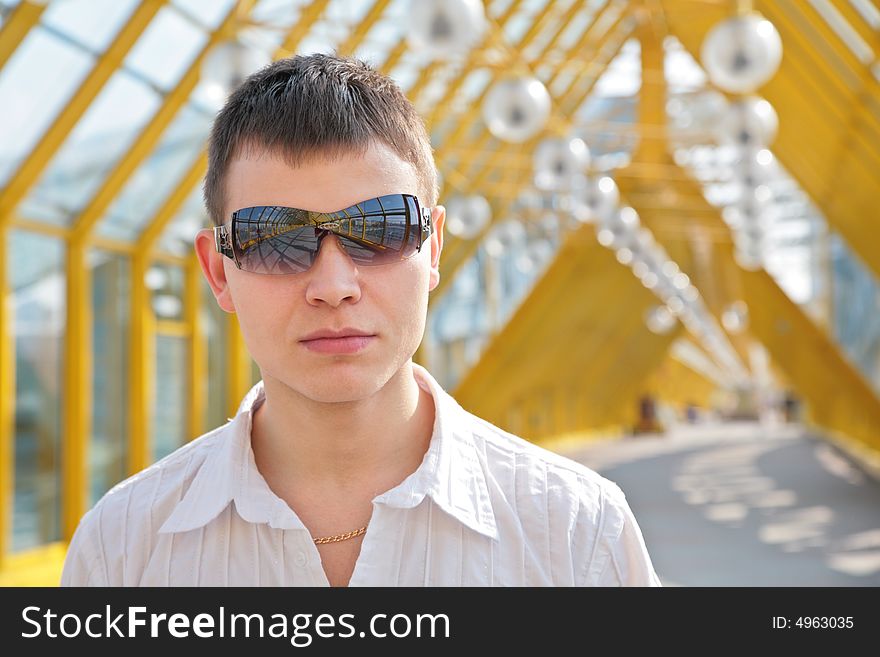 Young man in sunglasses on footbridge