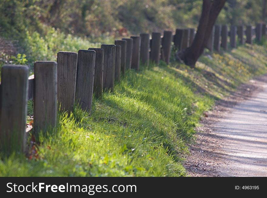 A path and a wooden fence leading away into distance. A path and a wooden fence leading away into distance.