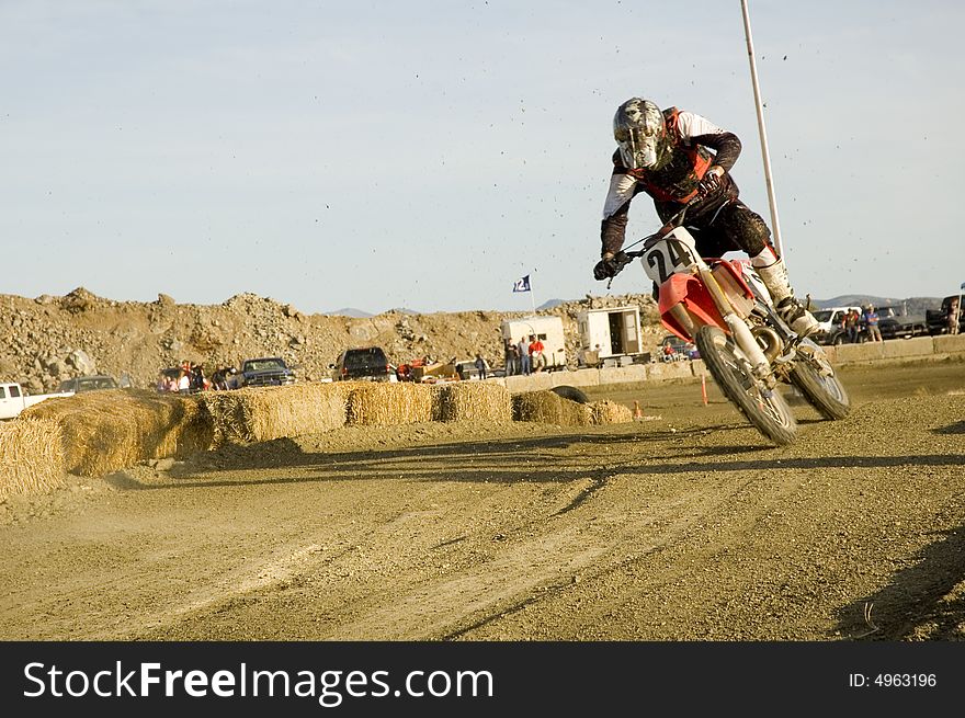 Dirt bike racer leaning into the curve and in the air
