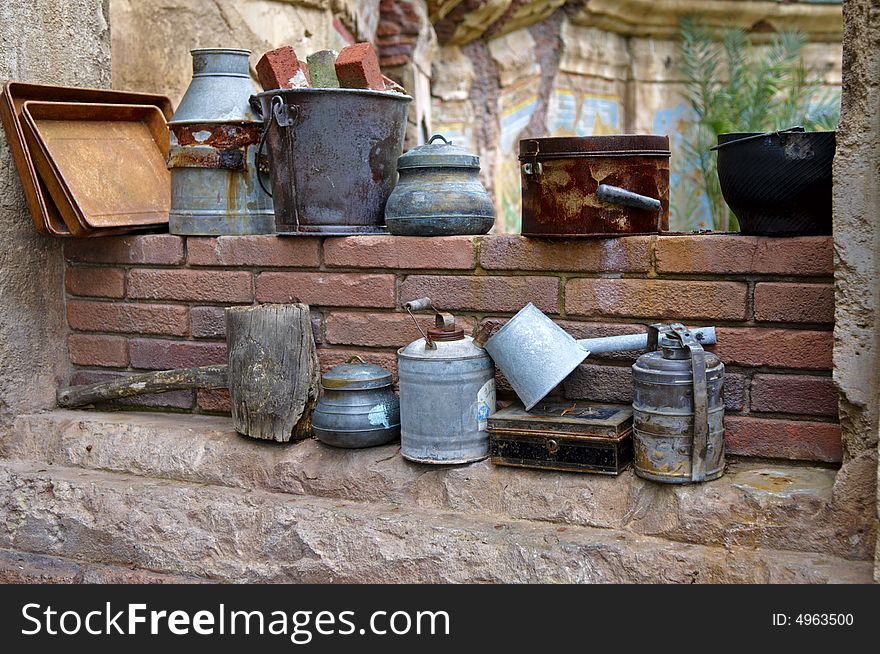 Various Utensils Perched On a Ledge by a Wall. Various Utensils Perched On a Ledge by a Wall