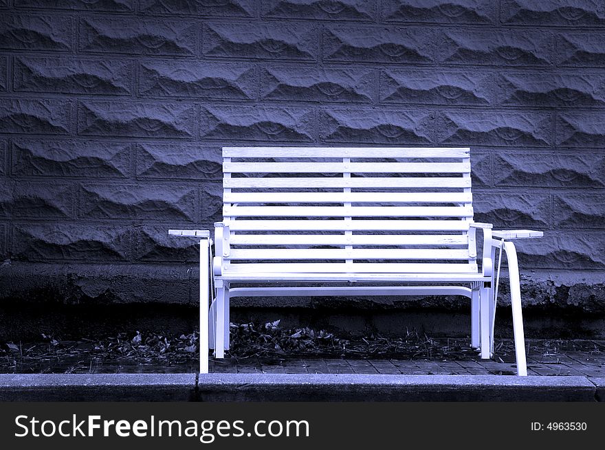 White park bench with gray brick background