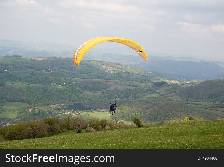 Two paragliders flying together on a cloudy day. Two paragliders flying together on a cloudy day