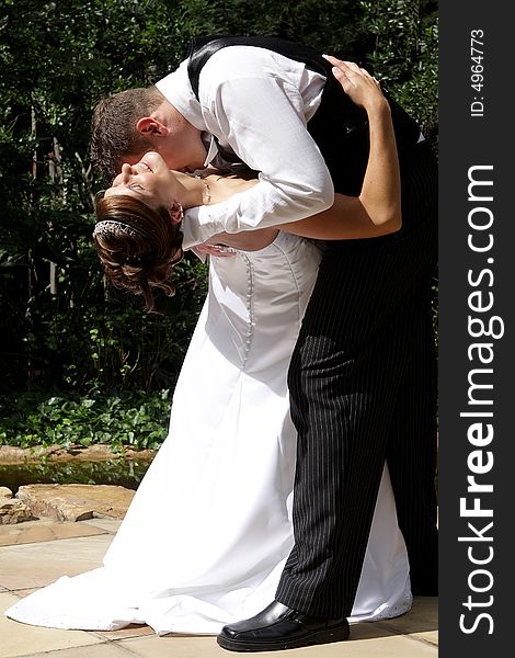A groom kissing his bride in the neck. A groom kissing his bride in the neck