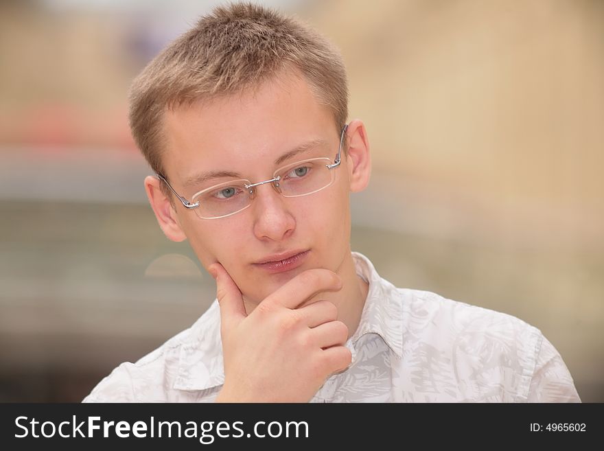 Thinking young man in the glasses