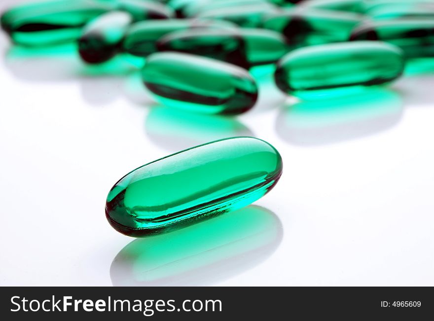 Green capsules on white background, horizontal image
