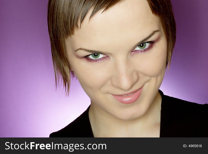 Beauty woman with green eyes on purple background, face close up