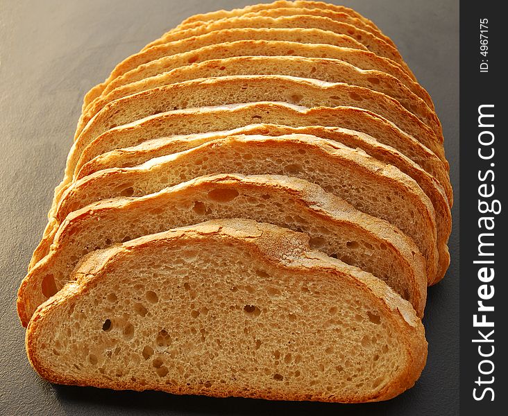 Large slices of crusty white bread on black background. Large slices of crusty white bread on black background