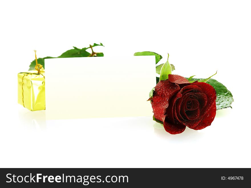 Red rose with a gift and blank card for congratulation over white