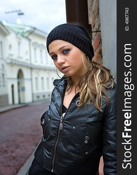 Portrait of the girl near wall in an old town