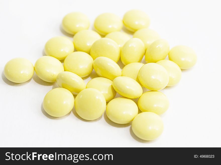 Yellow tablets close-up on the white background