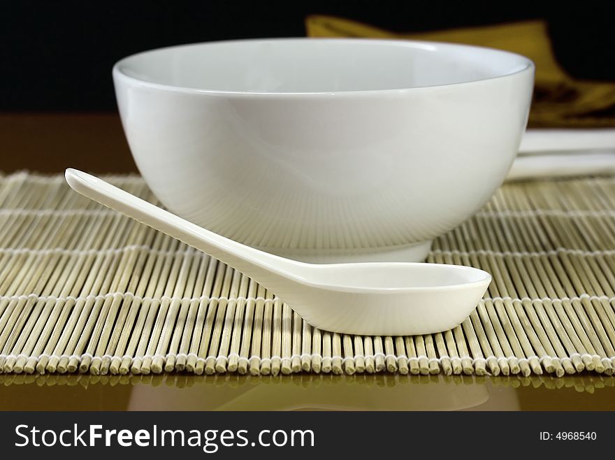 A table set for lunch with bowl and spoon in red. A table set for lunch with bowl and spoon in red