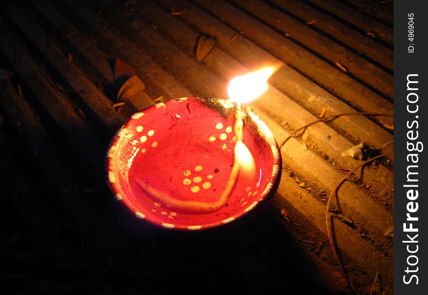 A red colored burning oil lamp kept in the dark