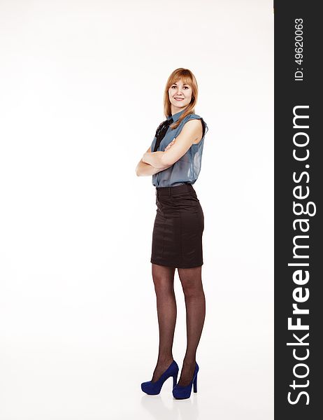 Young beautiful woman in blue blouse and black skirt posing standing