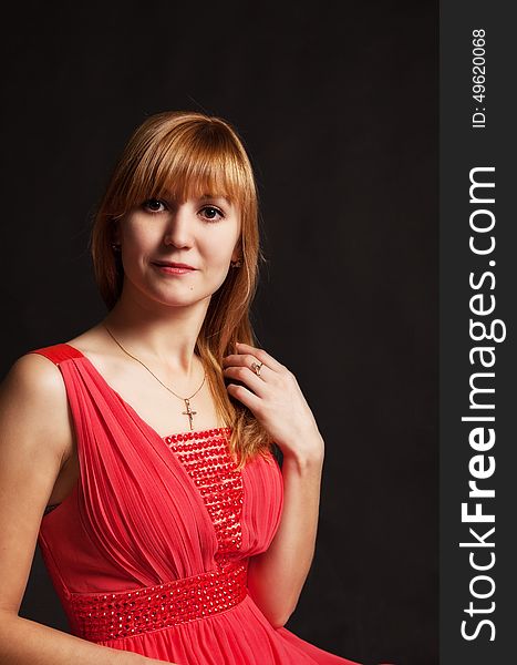 Portrait of a beautiful young woman in a red dress