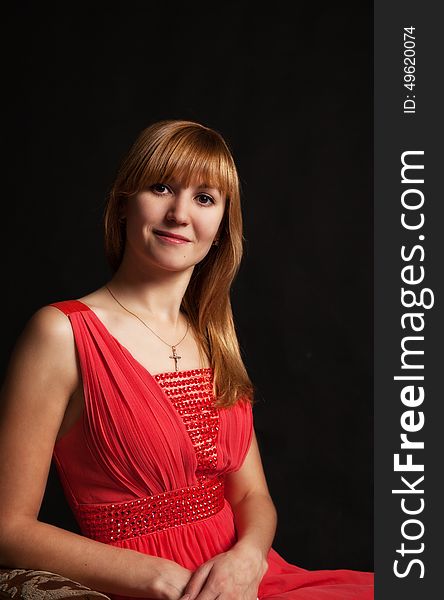 Portrait of a beautiful young woman in a red dress