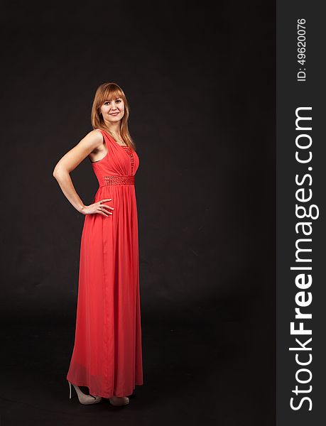 Young beautiful woman in red dress posing standing