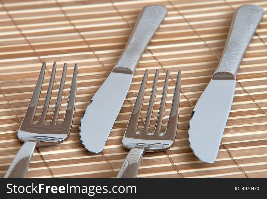 New table fork and knife on bamboo background