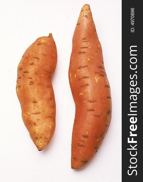 Two sweet potatoes aginst white background