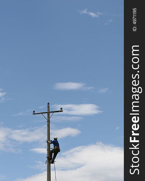 A worker climbs a pole to secure new power lines in Ecuador. A worker climbs a pole to secure new power lines in Ecuador