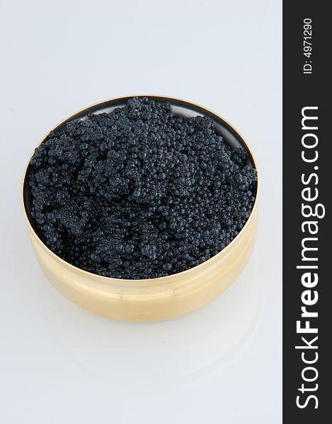 Black caviar in metal bowl on grey background.