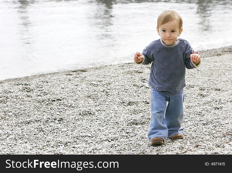 Baby boy on pebble beach