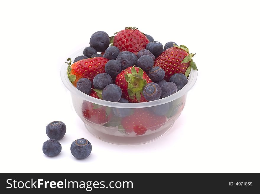 Blueberries and strawberries in a basket on white background