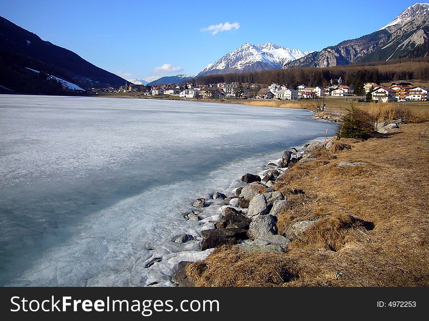 Alpine village on frozen lake