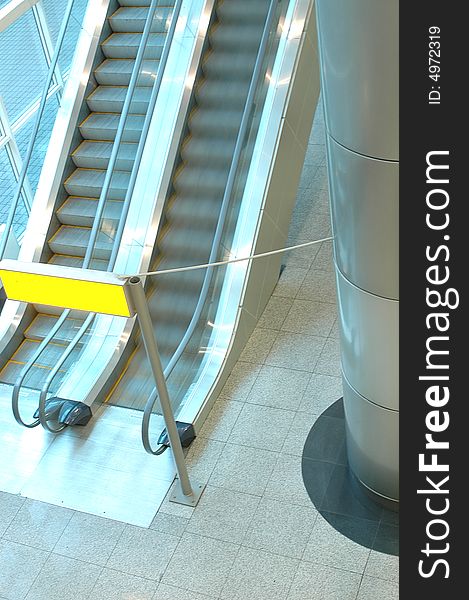 Two escalators go upwards with a yellow inscription