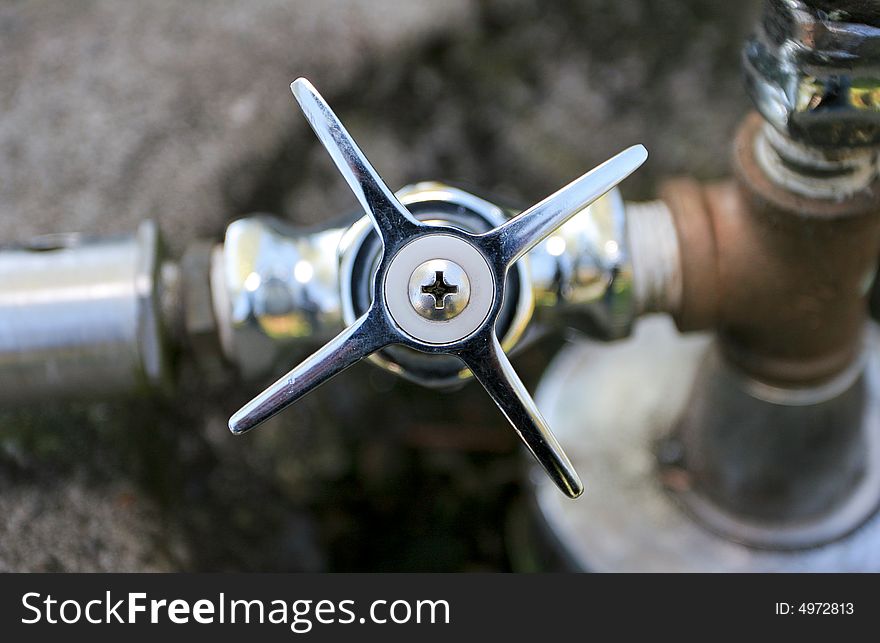 Shiny steel tap with on public drinking fountain. Shiny steel tap with on public drinking fountain.