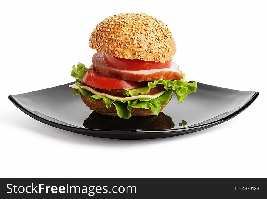 Close-up shot of sandwich on a black plate. Objects isolated on a white background.