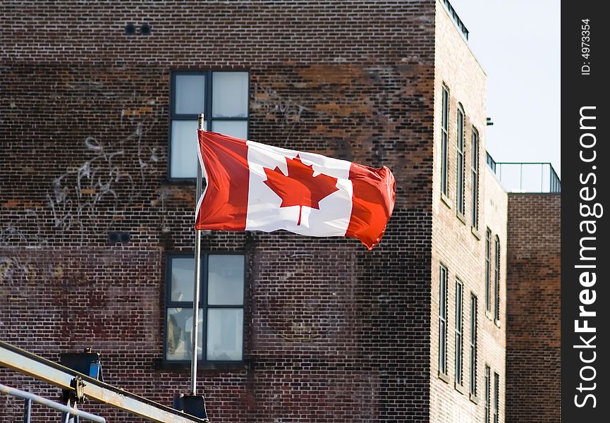 Canadian flag in front of administrative building with blue sky