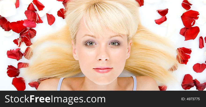 Beautiful young woman throwing rose petals against a white background. Beautiful young woman throwing rose petals against a white background