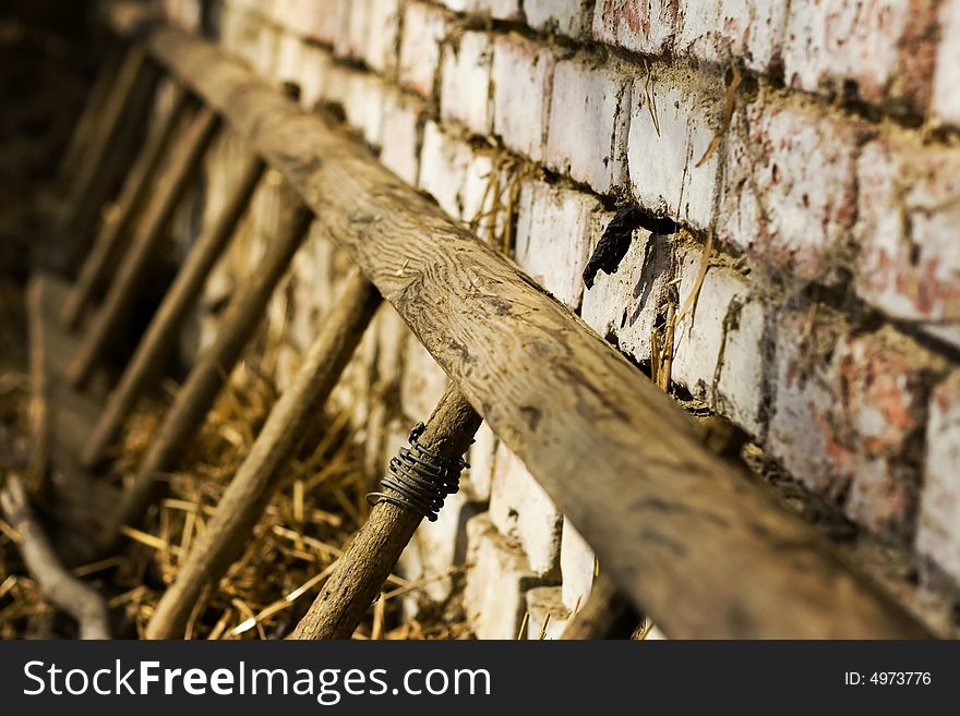 Old ladders laying on brick wall in haystack, shallow DOF