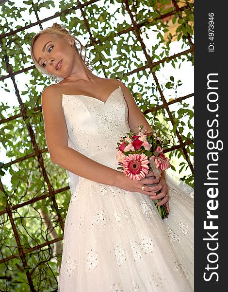 A bride standing outside in her wedding dress. A bride standing outside in her wedding dress