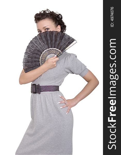 Cute brunette in grey dress with a black fan on white background. Cute brunette in grey dress with a black fan on white background