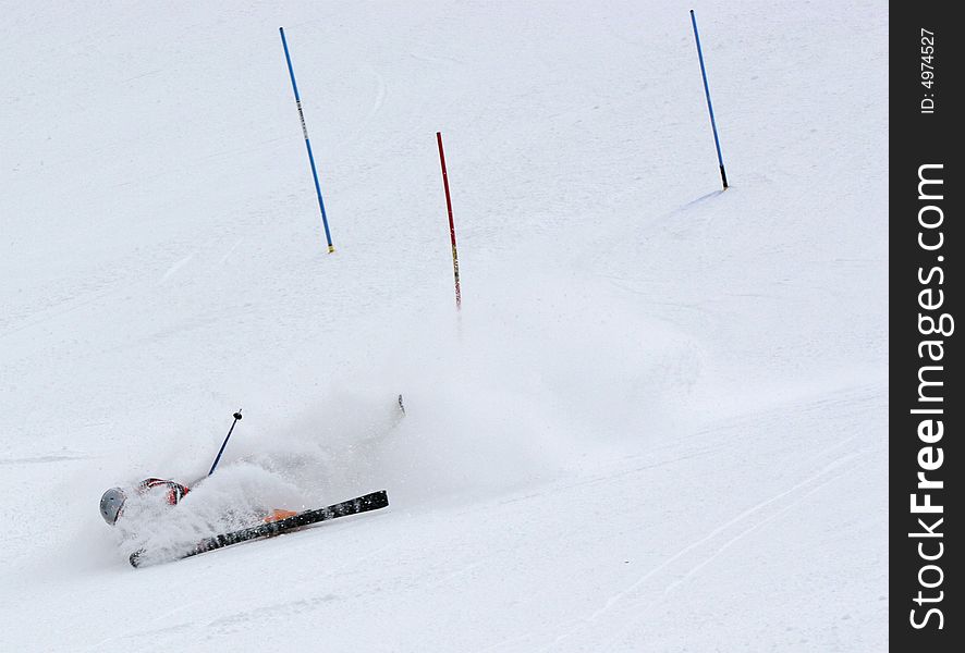 Skiier gets buried in snow kicked up from his skiis after wiping out. Skiier gets buried in snow kicked up from his skiis after wiping out