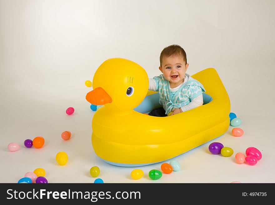 Cute baby girl in a big rubber ducky. Cute baby girl in a big rubber ducky