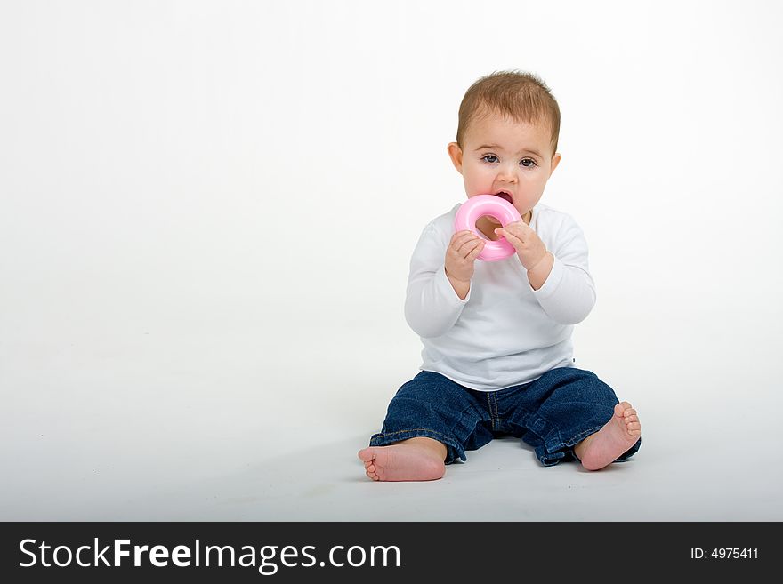 A baby playing with he little pink ring. A baby playing with he little pink ring