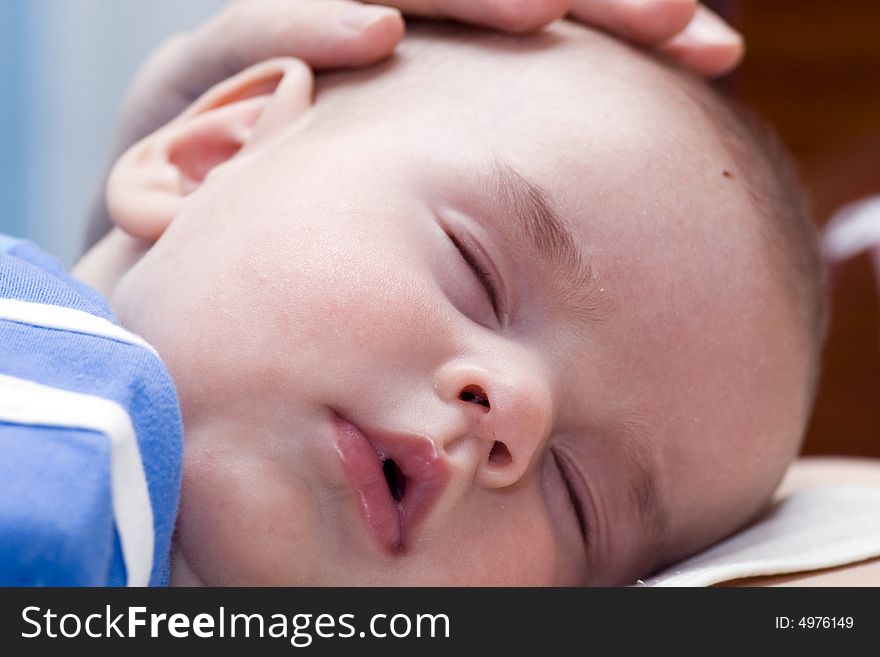 Newborn sleeping child in the hands of father