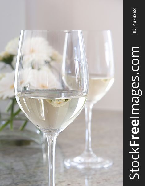 White wine in glass - flowers in background - close-up. White wine in glass - flowers in background - close-up