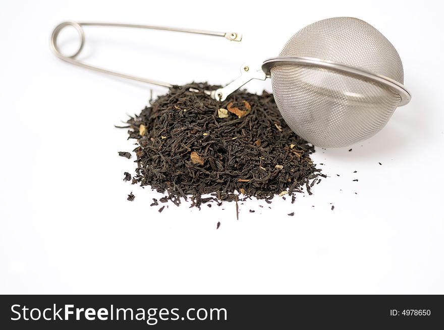 Dark tea with strainer and leaves on a white surface. Dark tea with strainer and leaves on a white surface