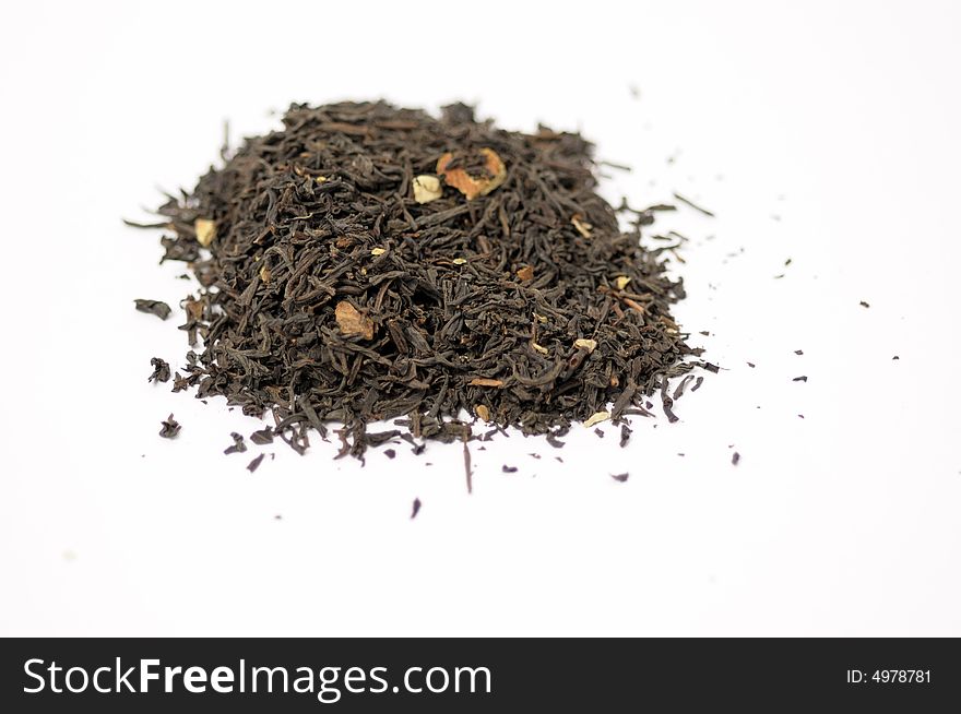 Dark tea leaves with almonds on a white surface. Dark tea leaves with almonds on a white surface
