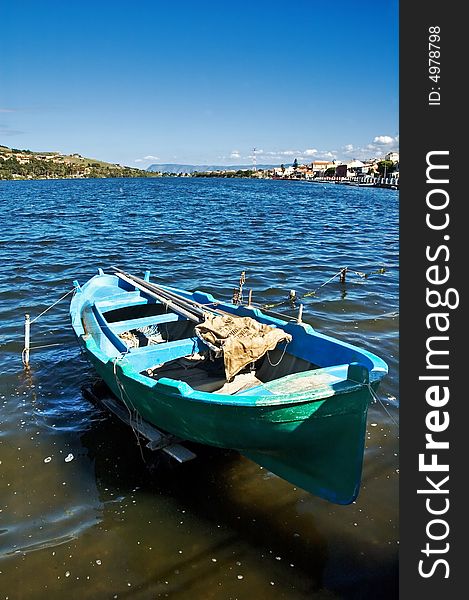 Old fisherman boat on lake with clear sky