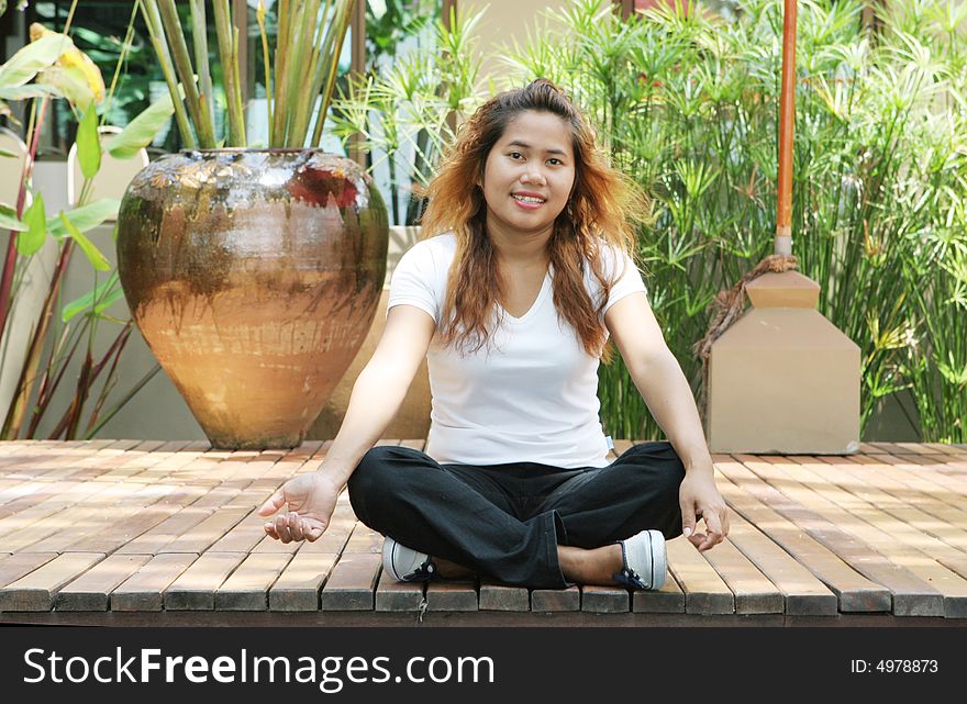 Portrait of an attractive young Thai girl sitting on a deck. Portrait of an attractive young Thai girl sitting on a deck.