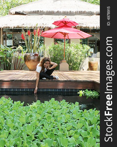 Portrait of an attractive young Thai girl sitting on a deck. Portrait of an attractive young Thai girl sitting on a deck.