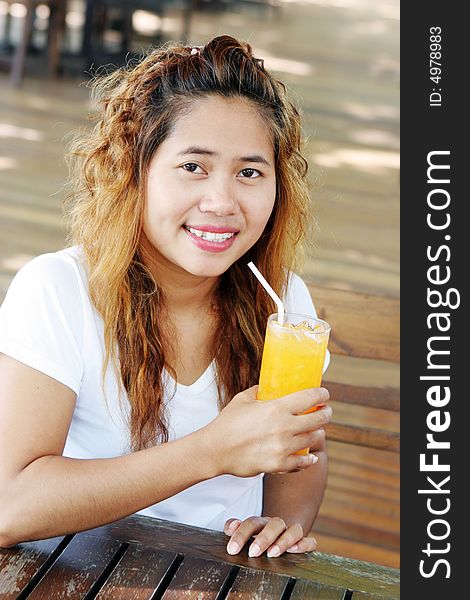 Pretty Asian girl having a drink at a cafe. Pretty Asian girl having a drink at a cafe.