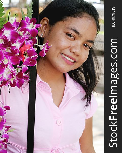 Portrait of a happy Thai woman with pink orchids. Portrait of a happy Thai woman with pink orchids.