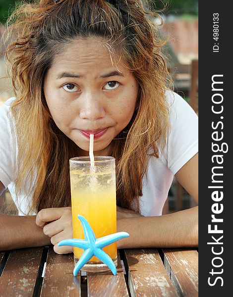 Close-up portrait of a pretty Thai woman drinking juice. Close-up portrait of a pretty Thai woman drinking juice.